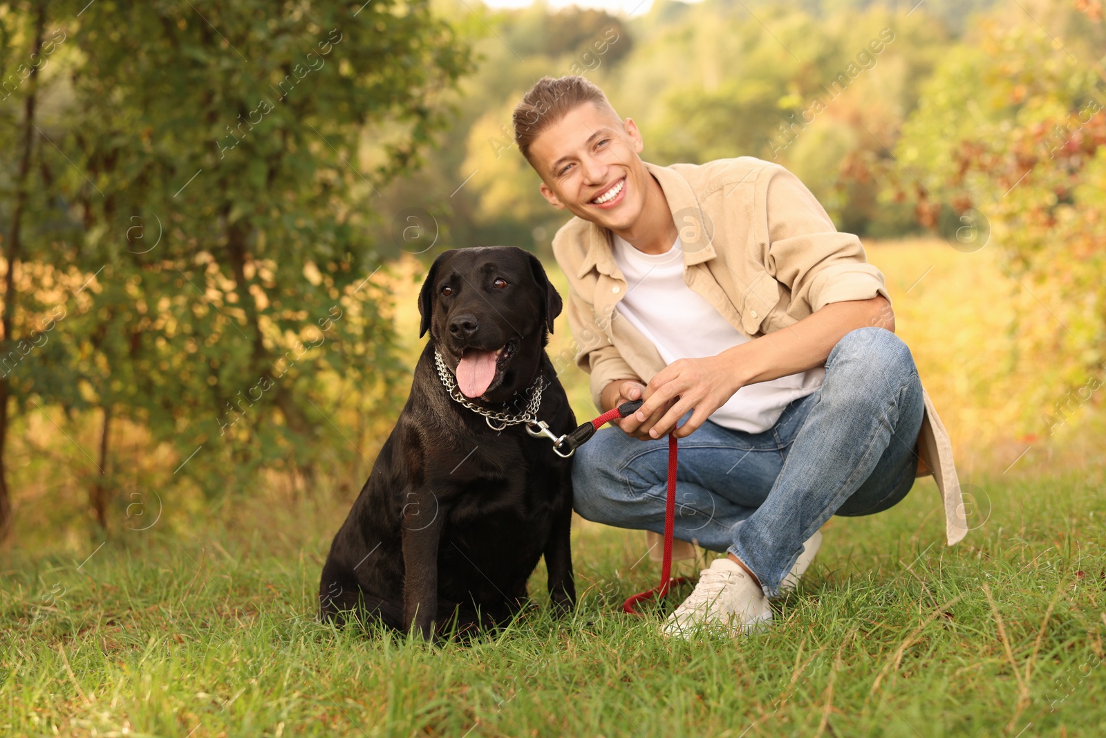 Photo of Smiling man with cute dog outdoors on autumn day