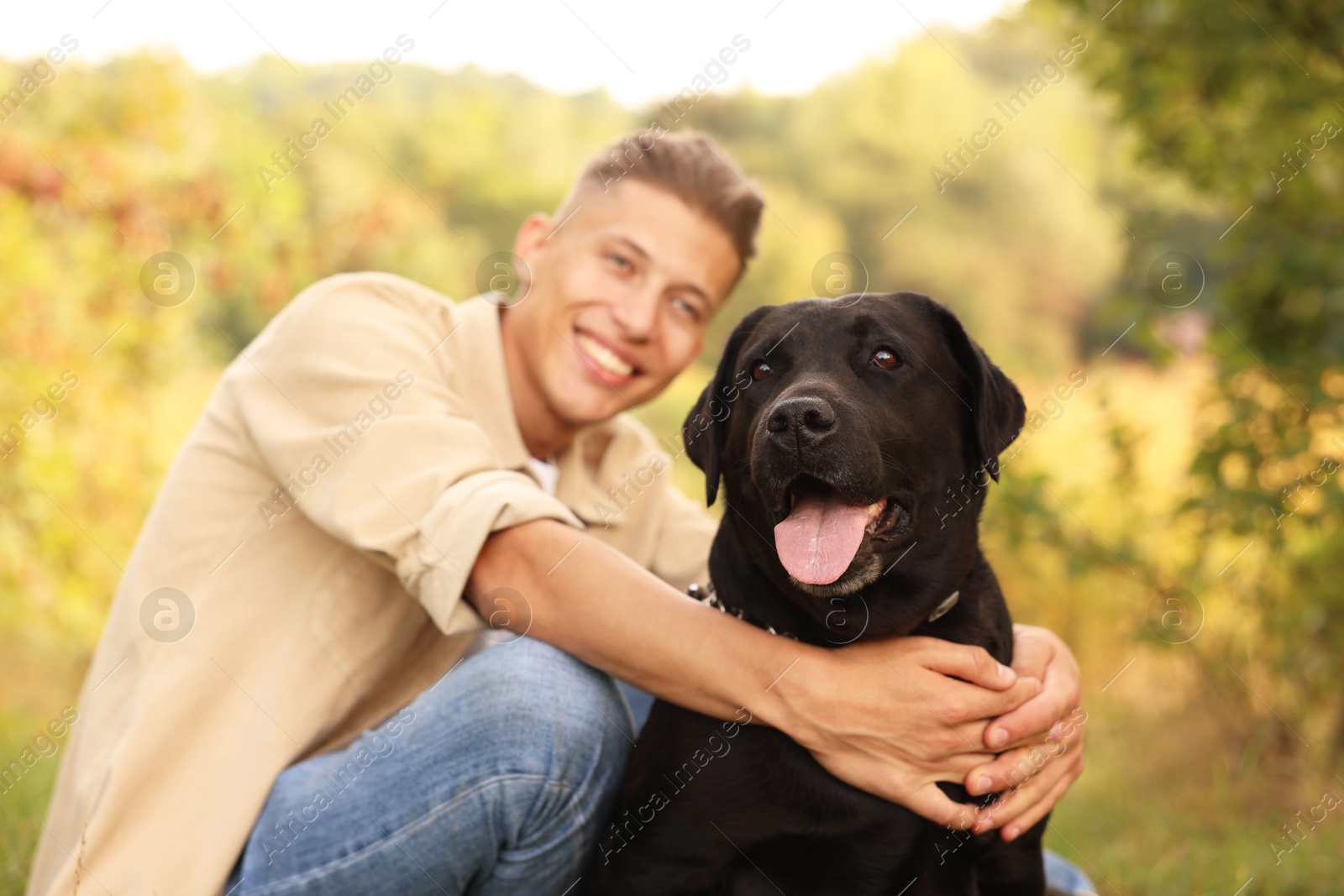 Photo of Cute dog with smiling owner outdoors, selective focus