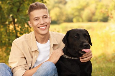 Photo of Smiling man with cute dog outdoors on autumn day