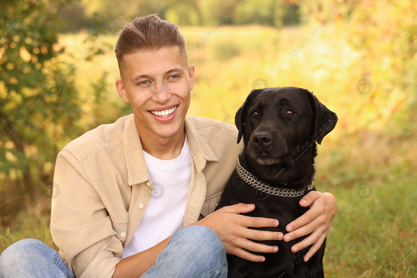 Photo of Smiling man with cute dog outdoors on autumn day