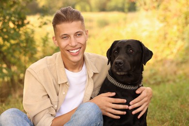 Smiling man with cute dog outdoors on autumn day