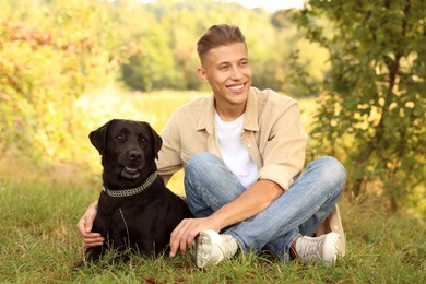 Photo of Smiling man with cute dog outdoors on autumn day