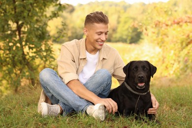 Smiling man with cute dog outdoors on autumn day