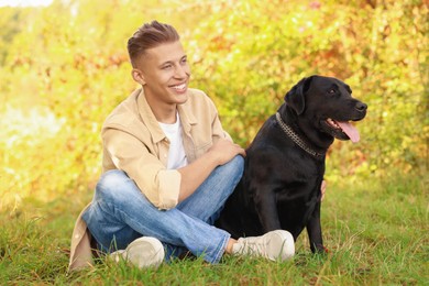 Photo of Smiling man with cute dog outdoors on autumn day