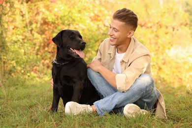 Photo of Smiling man with cute dog outdoors on autumn day