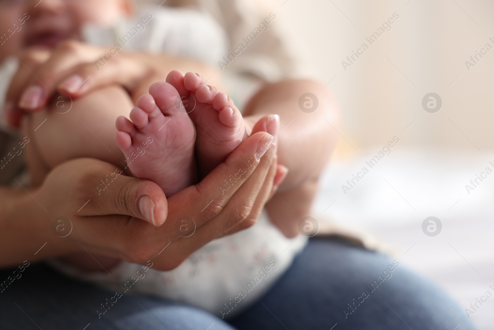 Photo of Mother with her cute little baby at home, closeup. Space for text