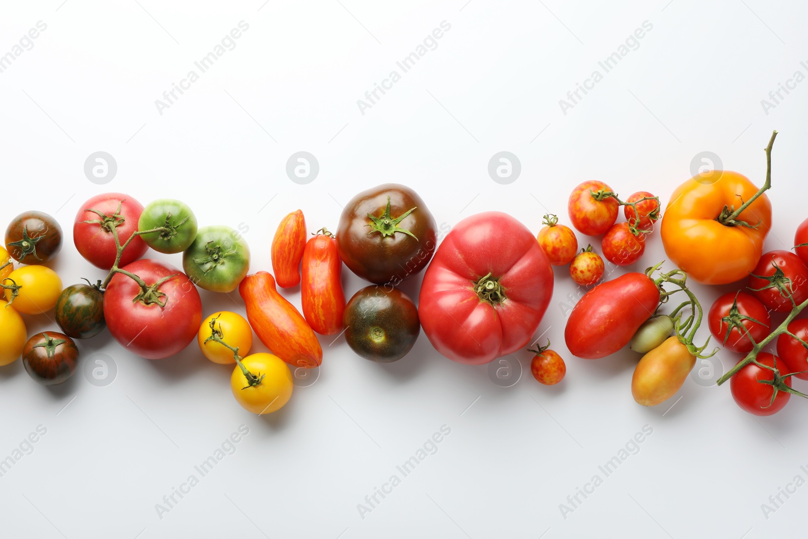 Photo of Different ripe tomatoes on white background, flat lay