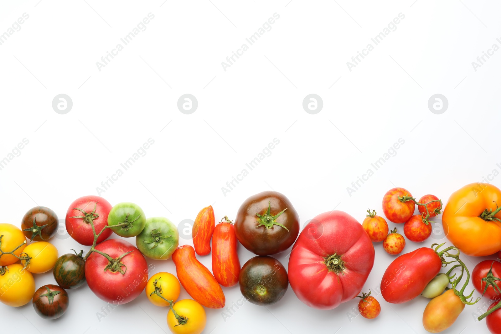 Photo of Different ripe tomatoes on white background, top view. Space for text