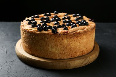 Photo of Delicious homemade blueberry pie on black table, closeup