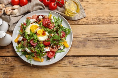 Photo of Tasty salad with arugula, egg, cheese and vegetables on wooden table, flat lay. Space for text