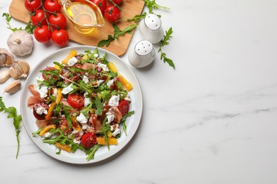 Photo of Tasty salad with arugula, cheese and vegetables on white marble table, flat lay. Space for text