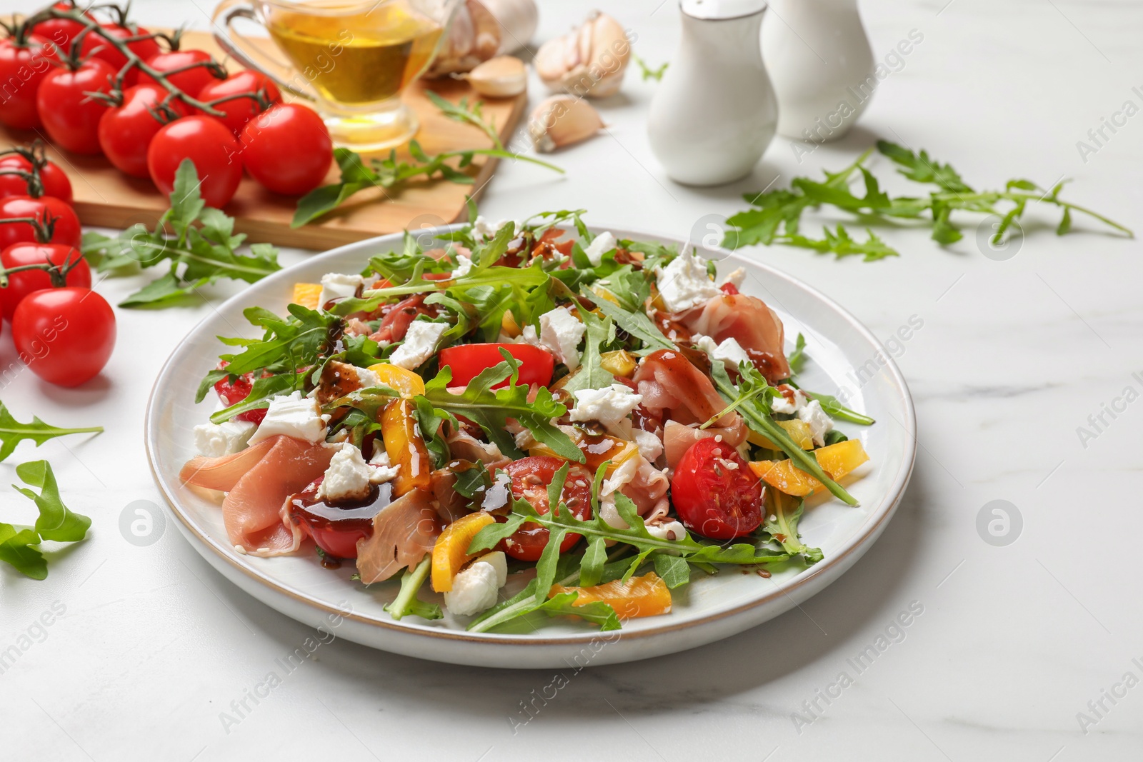 Photo of Tasty salad with arugula, cheese and vegetables on white table, closeup