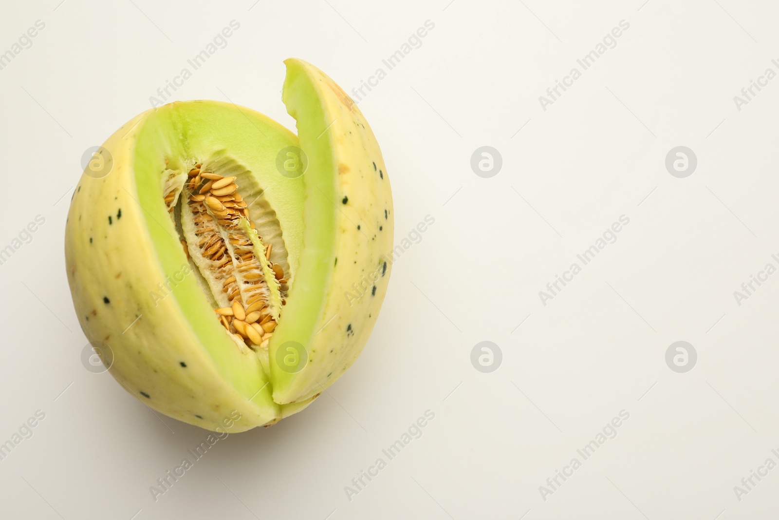 Photo of Cut fresh ripe honeydew melon on white background, space for text