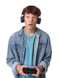 Emotional teenage boy in headphones playing video game with controller on white background