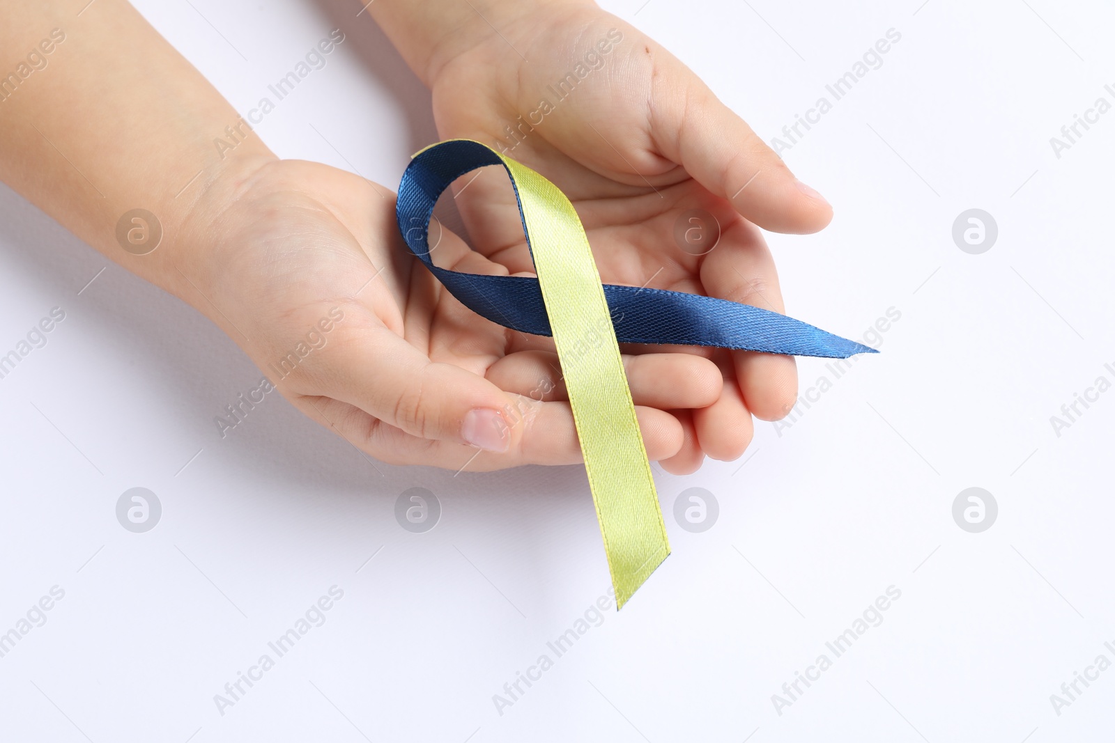 Photo of Child with yellow and blue ribbon on white background, closeup. Down syndrome awareness