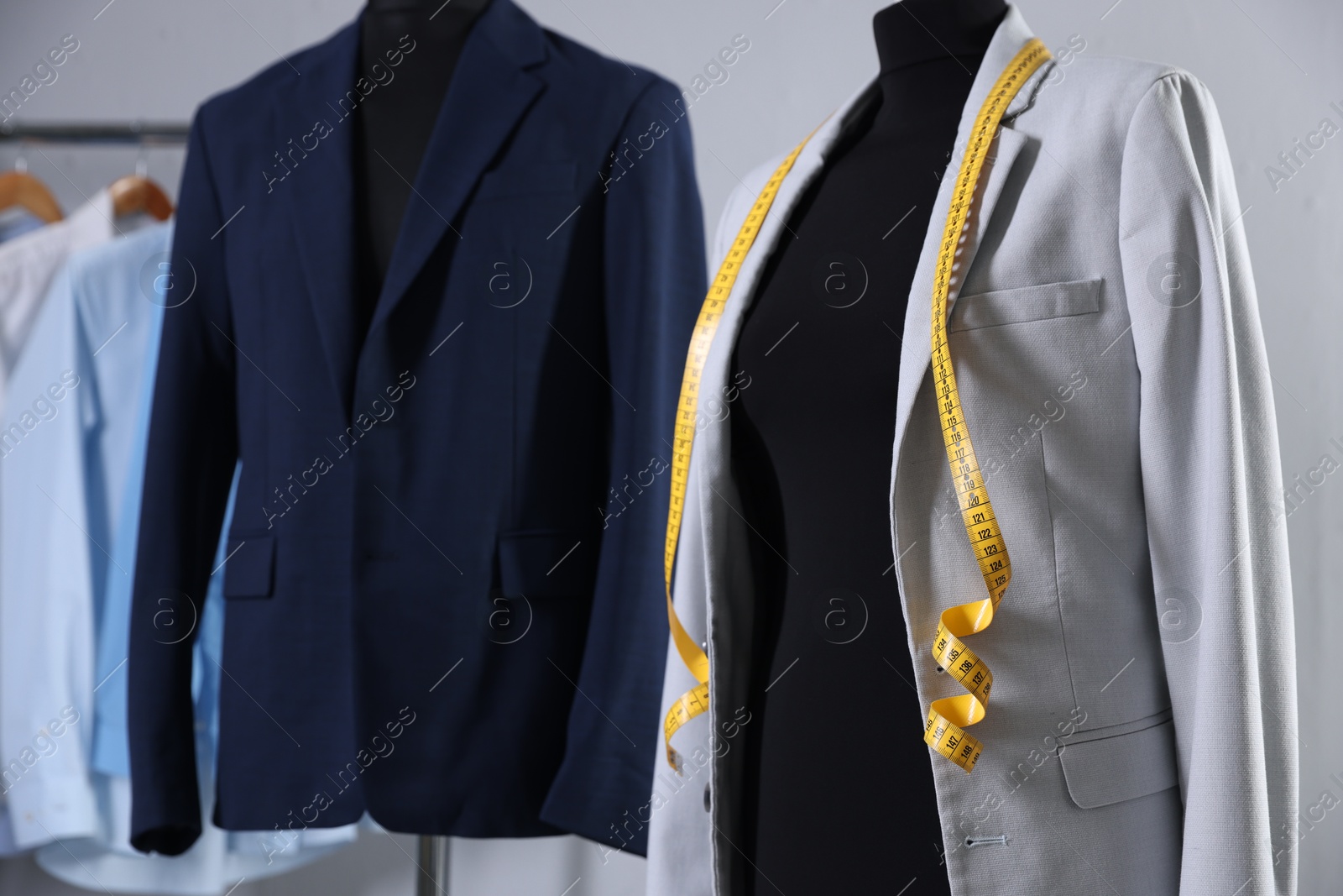 Photo of Female mannequin with jacket and measuring tape in tailor shop, closeup