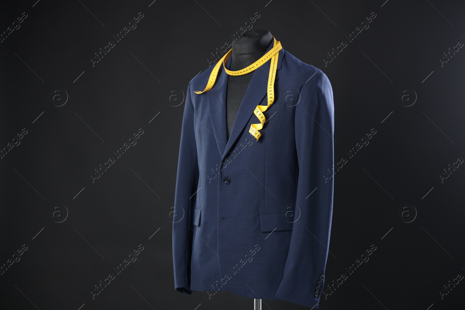 Photo of Male mannequin with jacket and measuring tape on dark background