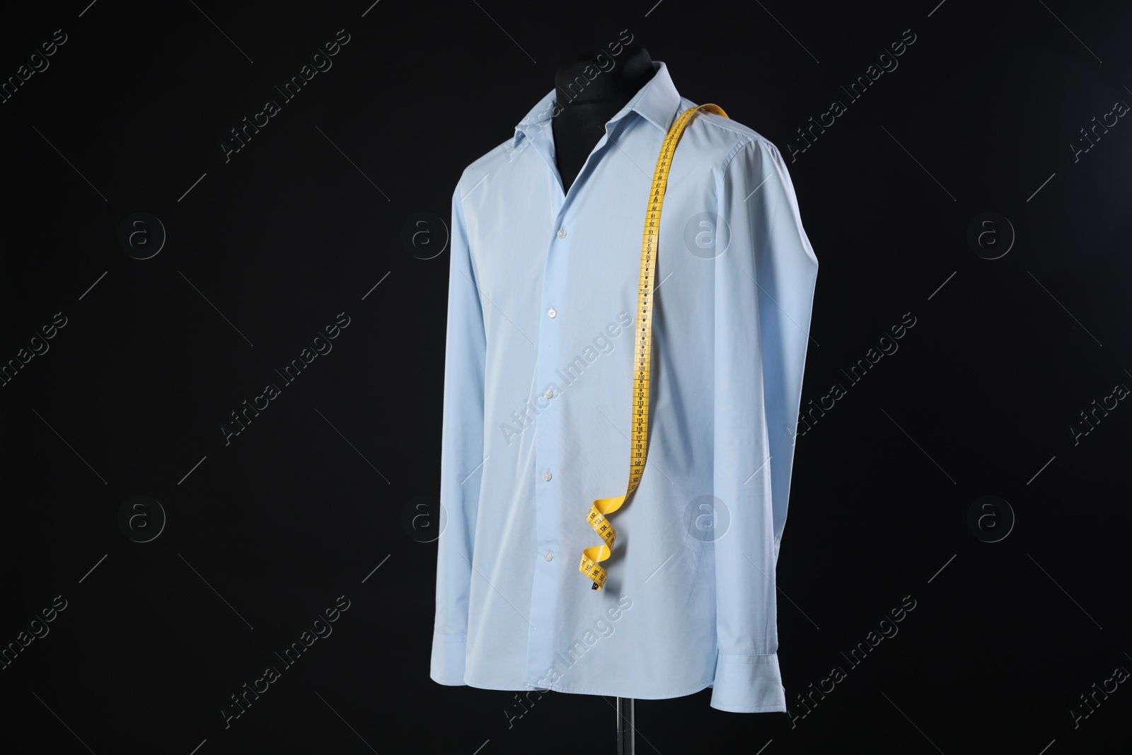 Photo of Male mannequin with shirt and measuring tape on black background