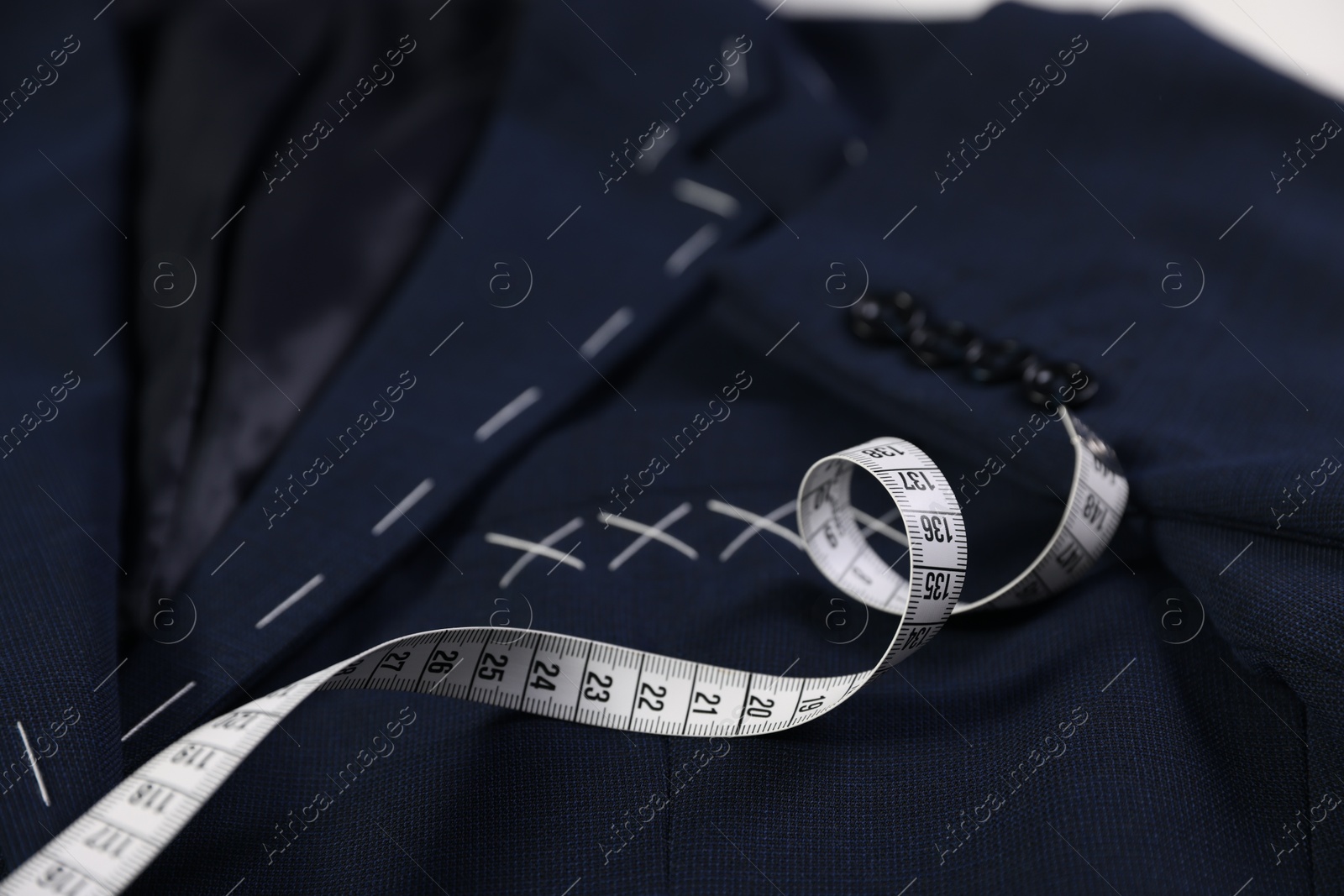 Photo of Elegant semi-ready jacket and measuring tape, closeup