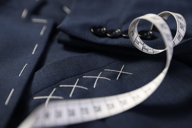 Photo of Elegant semi-ready jacket and measuring tape, closeup