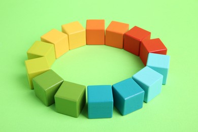 Photo of Many wooden colorful cubes on green background