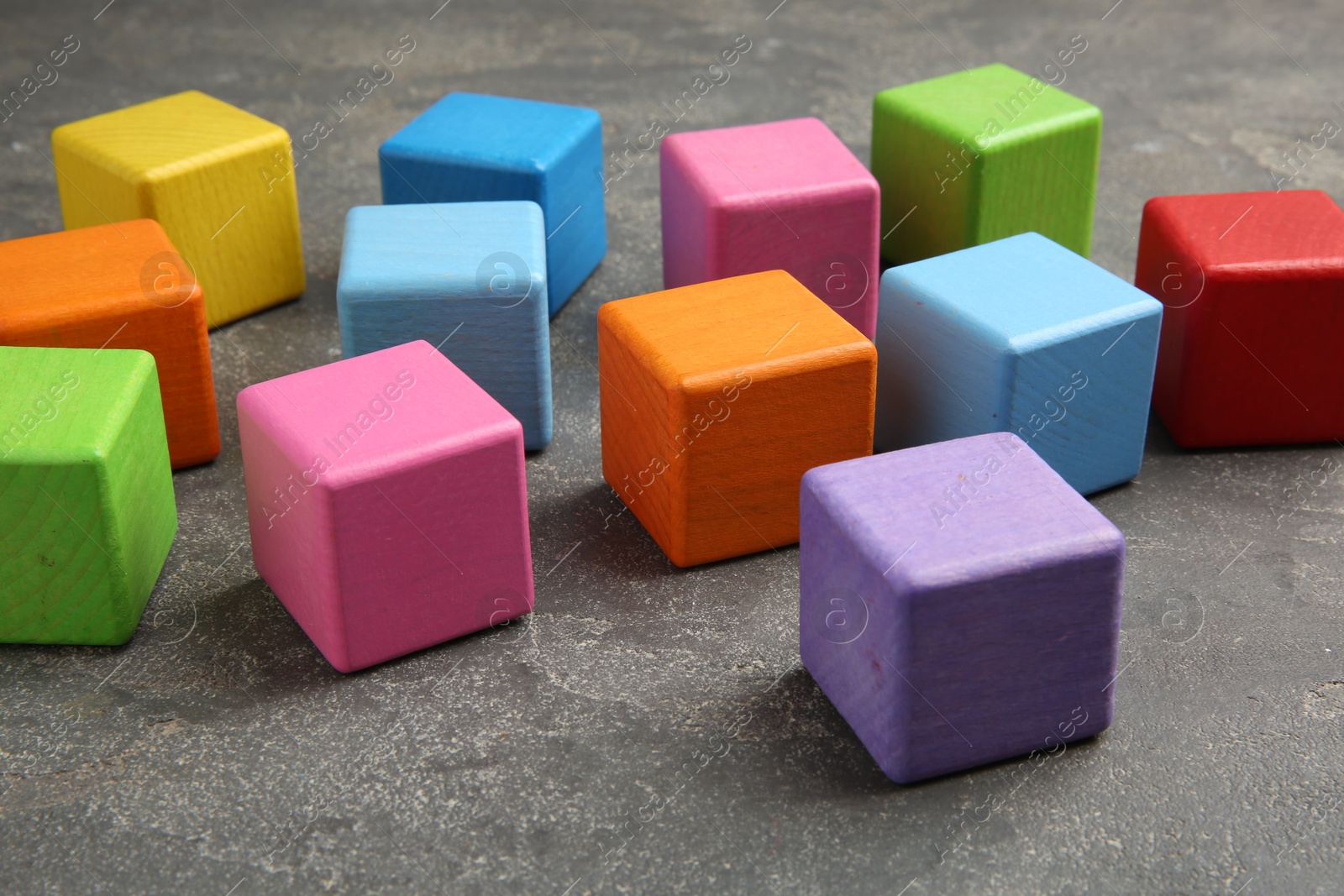 Photo of Many wooden colorful cubes on gray textured background, closeup