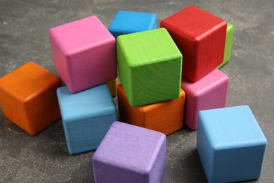 Photo of Many wooden colorful cubes on gray textured background, closeup