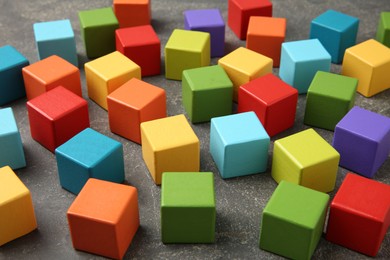 Photo of Many wooden colorful cubes on gray textured background, closeup