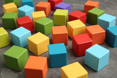 Photo of Many wooden colorful cubes on gray textured background, closeup