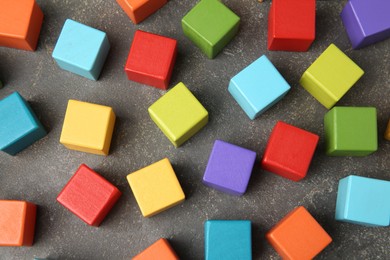 Photo of Many wooden colorful cubes on gray textured background, top view