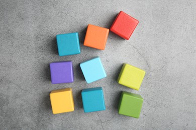 Photo of Many wooden colorful cubes on gray textured background, top view