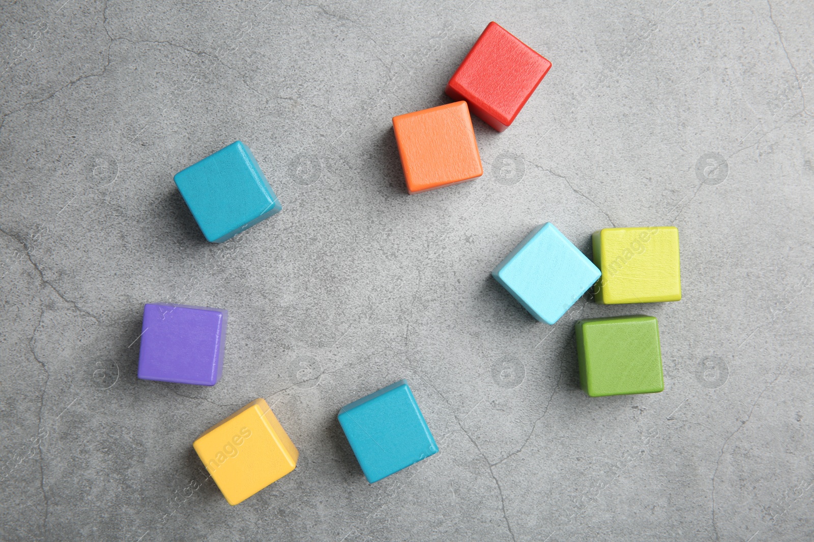 Photo of Many wooden colorful cubes on gray textured background, top view