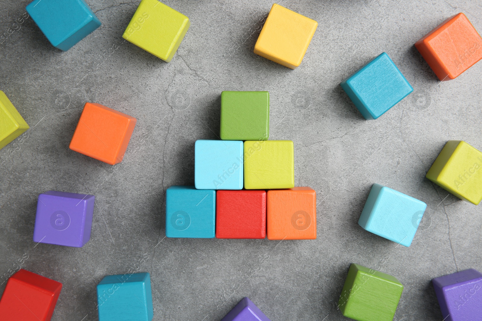 Photo of Many wooden colorful cubes on gray textured background, top view