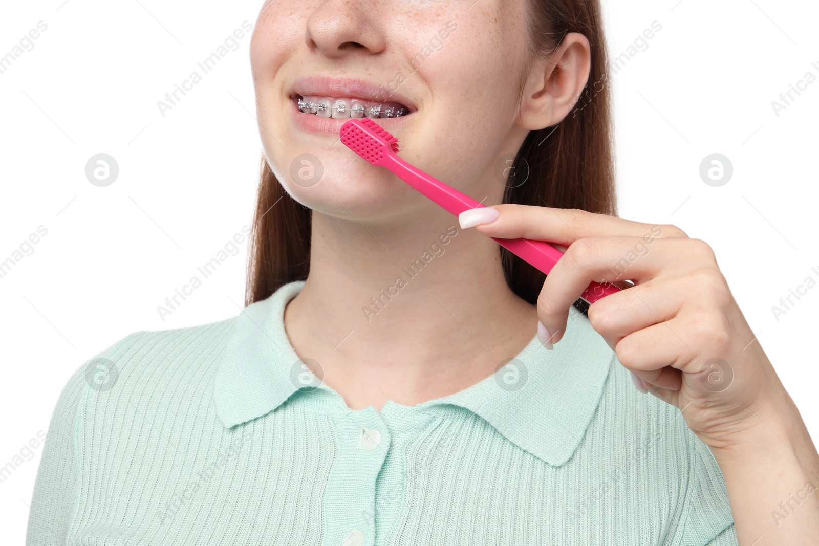 Photo of Girl with braces holding toothbrush on white background, closeup