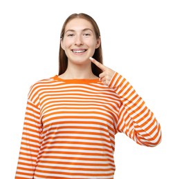 Photo of Smiling girl pointing at her braces on white background