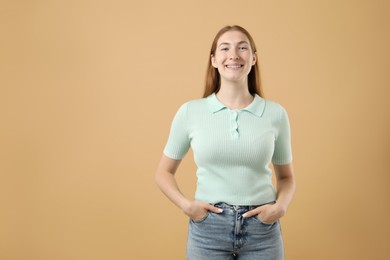 Photo of Smiling girl with braces on beige background, space for text