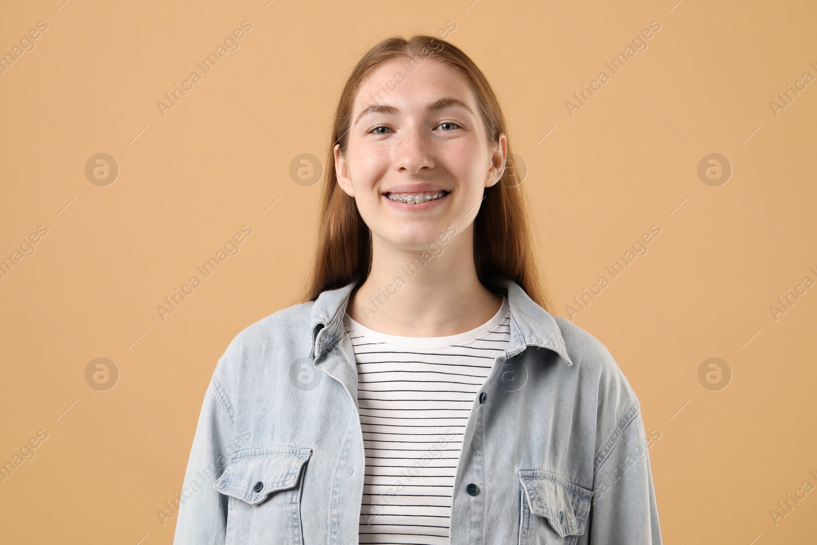 Photo of Smiling girl with braces on beige background