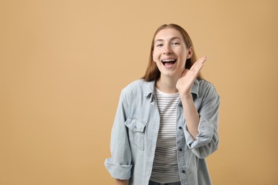 Photo of Smiling girl with braces on beige background, space for text