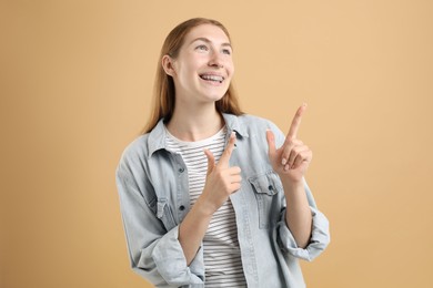 Photo of Smiling girl with braces on beige background