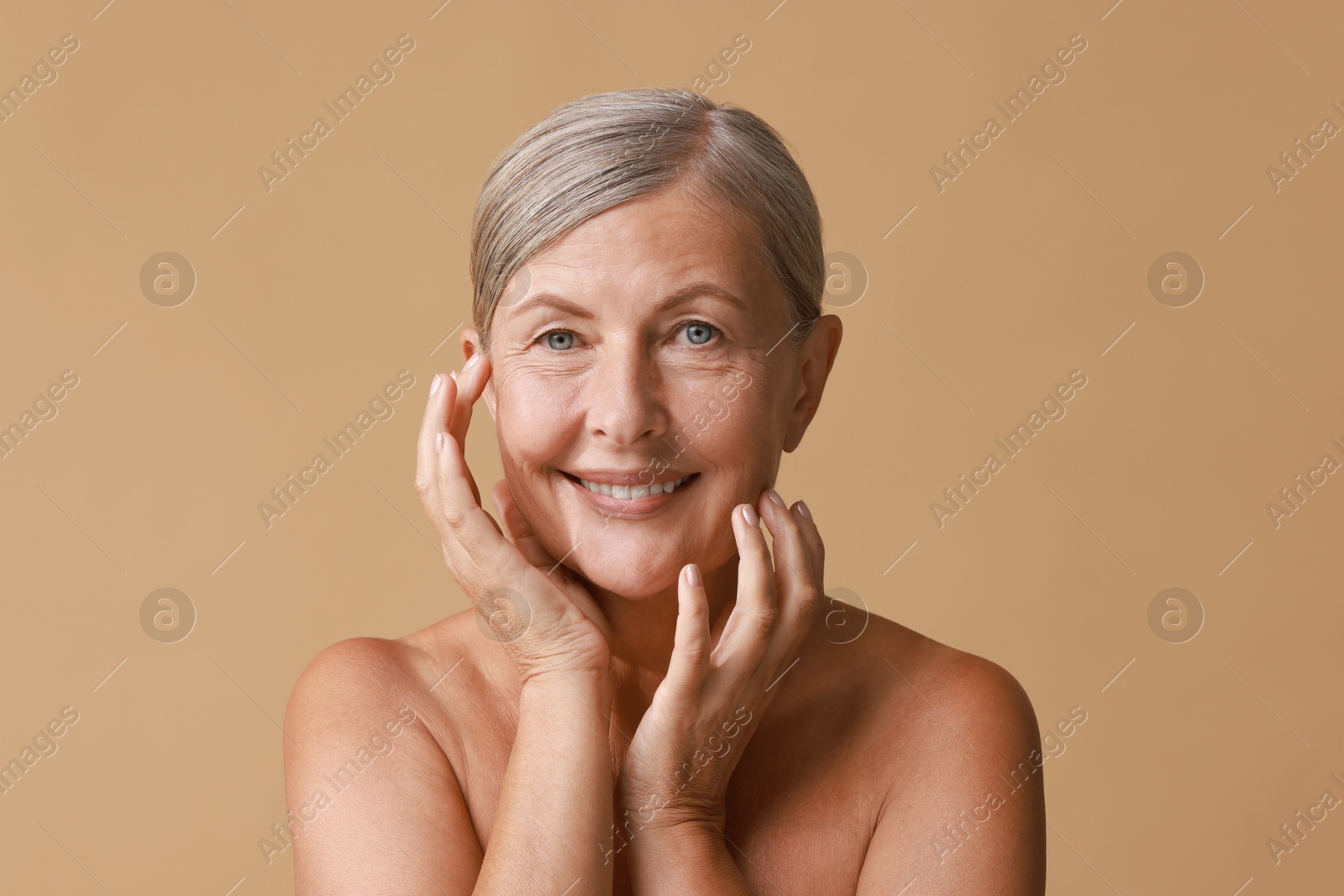 Photo of Face massage. Beautiful woman with healthy skin on beige background