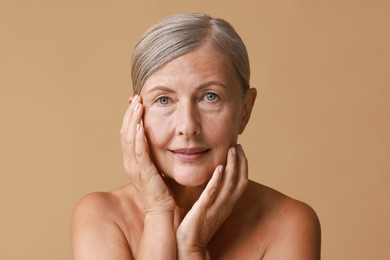 Photo of Face massage. Beautiful woman with healthy skin on beige background