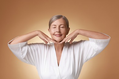 Face massage. Beautiful woman with healthy skin on beige background