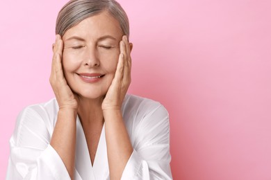 Photo of Face massage. Beautiful woman with healthy skin on pink background, space for text