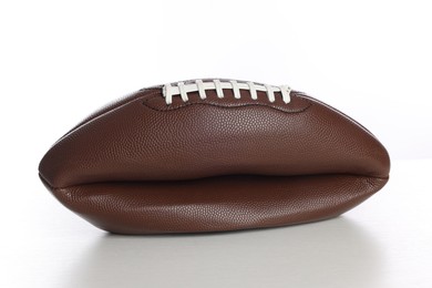 Photo of One deflated American football ball isolated on white