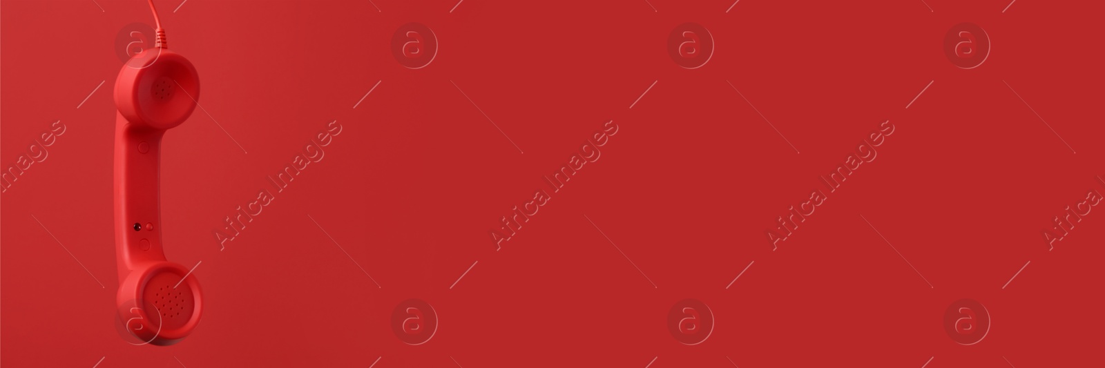 Image of Red corded telephone handset on red background. Banner design with space for text