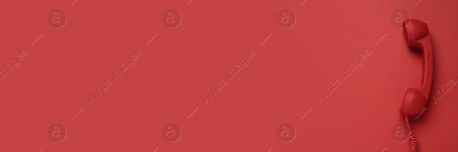 Image of Red corded telephone handset on red background, top view. Banner design with space for text