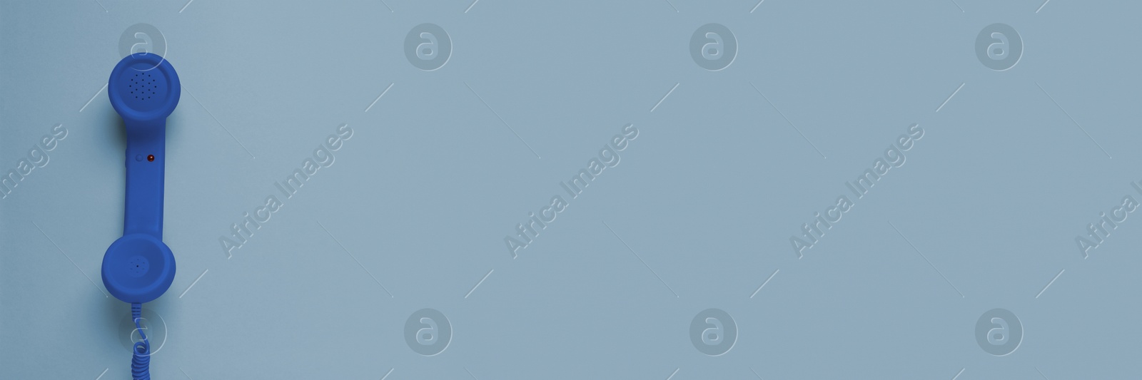 Image of Blue corded telephone handset on grey background, top view. Banner design with space for text