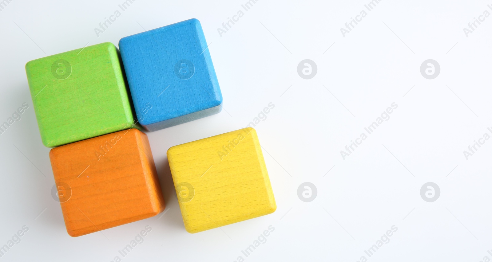 Photo of Many wooden colorful cubes on white background, top view. Space for text