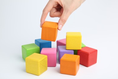 Photo of Woman with colorful cubes on white background, closeup