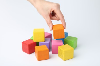 Photo of Woman with colorful cubes on white background, closeup